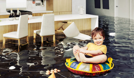 Boy sitting on tub in flooded house